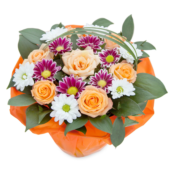 Set against a crisp white background that makes every detail shine, this radiant floral bouquet is a testament to the artistry of New Malden's seasoned florists. The arrangement is viewed from above, framing a vivid blend of peach and orange roses at its centre-each petal carefully unfurled, their soft gradient hues suggesting the mellow glow of sunset over the streets near High Street. Accompanying these are exquisite white chrysanthemum clusters, their delicate petals fanned elegantly around subtle green centers, along with deep magenta and purple blooms radiating energy from vivid yellow-green discs. Dense, glossy greenery-likely ruscus-brings a luxurious depth and anchors the composition, peeking from beneath the blossoms to create contrast and volume. A slender strand of bright green bear grass arcs gracefully overhead, echoing the gentle curves found in local gardens and lending a touch of modern grace. The bouquet's base is expertly girded with orange tissue or cellophane, crinkled and bright, tying the warm tones together and suggesting a lovingly prepared gift or centrepiece for an intimate celebration. This beautifully arranged bouquet embodies feelings of happiness, appreciation, and togetherness-a perfect choice for congratulating a neighbour, commemorating a birthday, or simply brightening a home in New Malden with a fresh splash of colour and artistry.