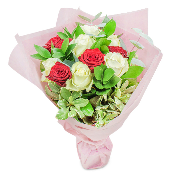 This visually striking bouquet, artfully presented against a crisp white backdrop, showcases the sophisticated mastery of a New Malden florist attuned to the area's unique style and sentiment. The focal point is a meticulously balanced array of approximately twenty roses-rich, velvety reds mingling with creamy whites-each rose at the peak of its bloom, petals unfolding in intricate, undulating spirals that signal both freshness and exquisite quality. Interspersed handsomely among the blooms, glossy ruscus leaves give a deep verdant foundation, while fuller, succulent-like pale green leaves introduce subtle variety in hue and shape. Feather-light silver-green eucalyptus sprigs create a feathery, airy lift, and variegated foliage, edged with delicate cream, brings a painterly, organic feel to the arrangement. Enveloped in generous wraps of soft, translucent pastel pink paper, the hand-tied bouquet holds a domed, abundant form that exudes celebration and sophistication-perfect for romantic occasions, commemorating milestone anniversaries in the heart of New Malden, or offering a thoughtful gesture along the leafy avenues of Old Malden. Every element-from the satin-smoothness of each petal to the refreshing garden scent of the lush greenery-speaks to the attentive care and experienced eye of a local florist. Whether adorning a dinner table on a quiet Worcester Park evening or brightening the entryway for a family event, this bouquet embodies the joy of giving and the grace of New Malden's floral artistry, ensuring your message of love or congratulations is delivered in the most unforgettable way.