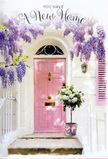 A soft, romantic doorway in New Malden is captured at the very moment it feels ready to welcome its new owners. The focal point is a pale pink front door, its surface smooth and freshly painted, standing out against whitewashed walls that lend a clean, timeless backdrop. Just beside it, a softly coloured shutter adds charm and balance, while from above, lush wisteria in shades of lavender and lilac spills downward in graceful clusters. The blossoms form a natural canopy, their dangling flowers creating dappled shadows that dance across the step and door as the light shifts. At the threshold, a generous floral arrangement rests in a simple grey metal bucket, crafted with care by a local New Malden florist. The bucket brims with white and cream roses, each bloom plush and full, surrounded by airy green foliage that adds texture and freshness. A satin pink ribbon is tied carefully around the base, mirroring the front door's hue and bringing a sense of cohesion and romance to the entire composition. This could be an entrance on a sidestreet near Malden Manor or a leafy corner close to Beverley Brook, where new homeowners arrive to find flowers waiting with quiet joy. The scene feels calm yet celebratory, with the gentle fragrance of wisteria and roses imagined on the air, hinting at housewarming gatherings, shared laughter, and cosy evenings ahead. It is an image of understated beauty, perfectly suited to expressing congratulations on a move and the comforting promise of a welcoming, flower-filled home in New Malden.
